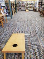 Photo of 2 cornhole boards set up on library lower level