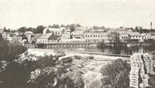 Black and white photo of a lake and houses